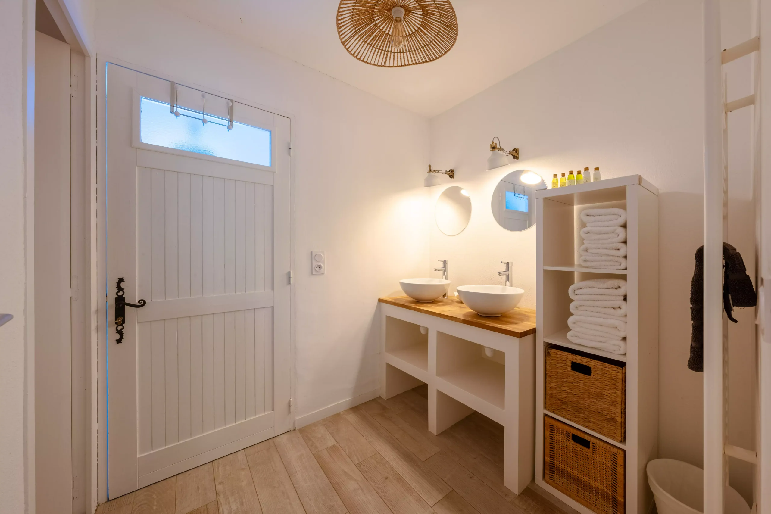 Villa Le Perchoir - Salle de bain double vasque, murs blancs et miroirs ronds.