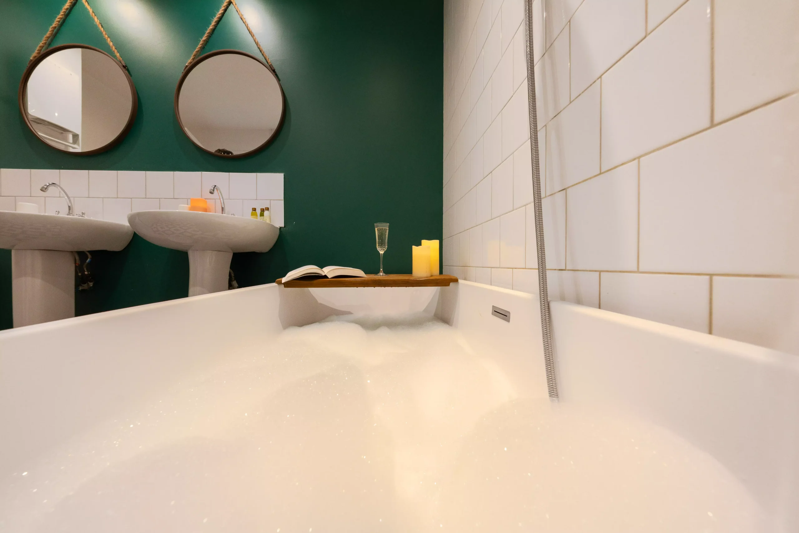 Villa Le Perchoir - Baignoire avec de la mousse et les doubles vasques au fond.