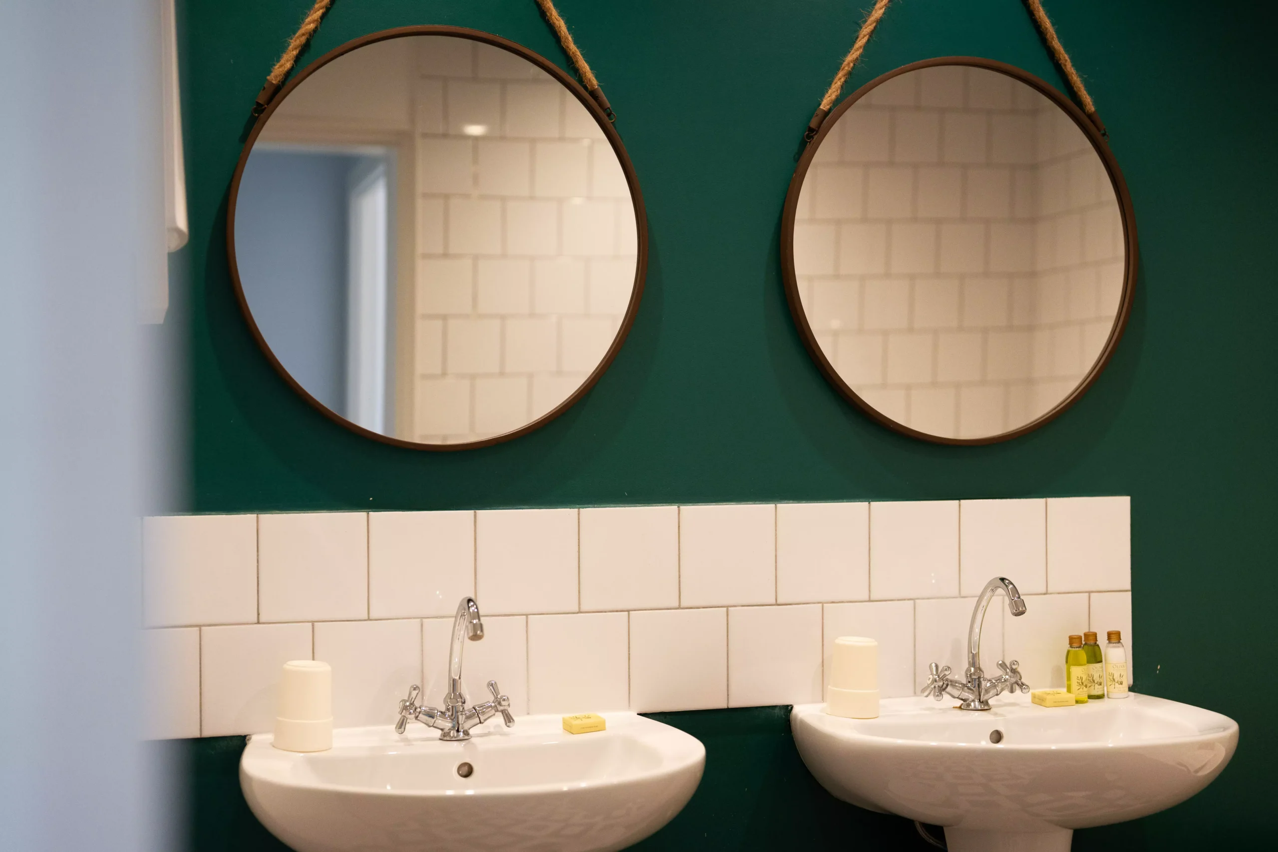 Villa Le Perchoir - Deux vasques dans une salle de bain, deux miroirs et des produits de beauté.